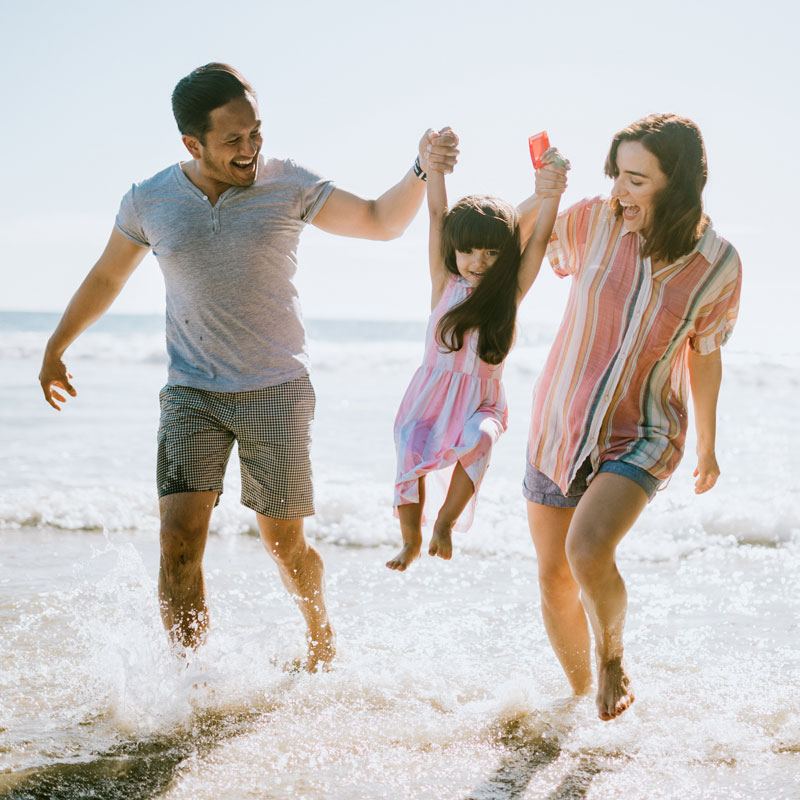 Family Holding Hands On Beach